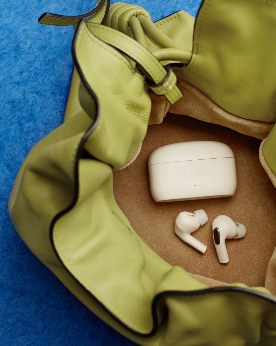 Sudio E3 Cream White TWS earbuds in a bag