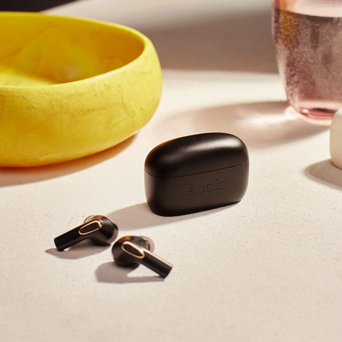 Sudio E3 Black TWS earbuds on a white table